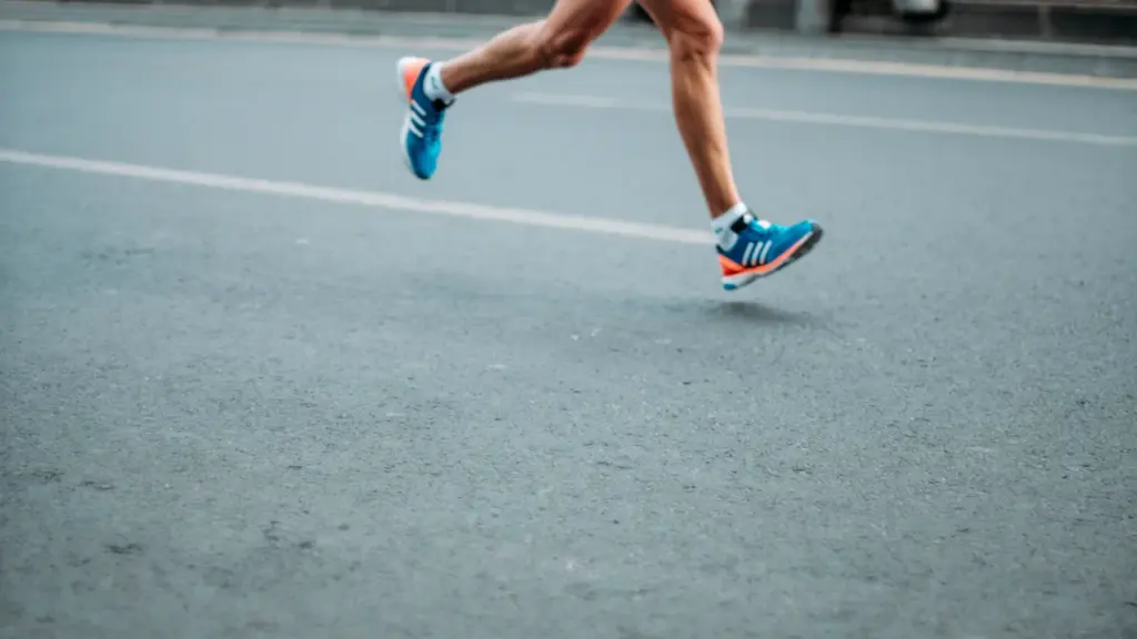 Close up of running shoes in motion on an asphalt road surface.