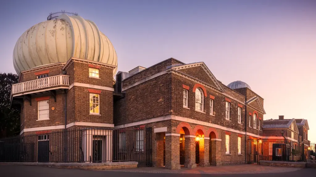 The historic Royal Observatory in Greenwich illuminated by warm sunset light.