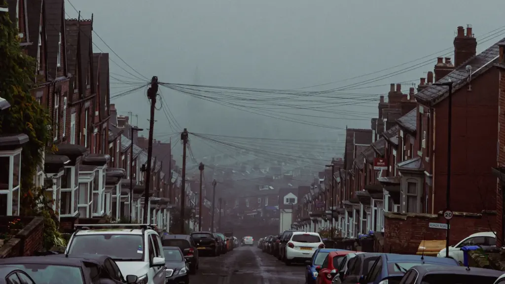 A residential British street with parked cars on a moody autumn afternoon.