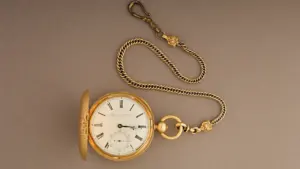 Antique gold pocket watch with chain, representing the Victorian era of railway expansion.