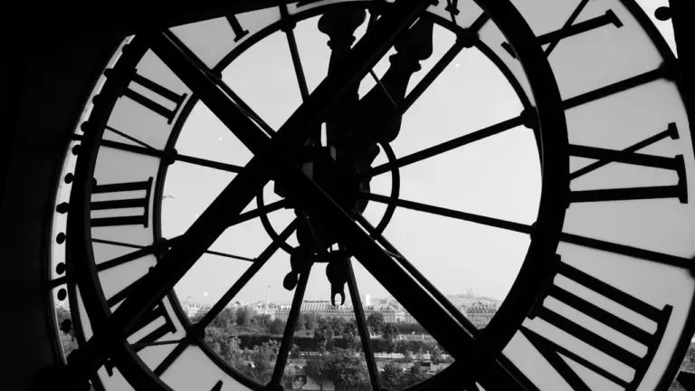 Close-up of a large outdoor clock face against a bright sky background.